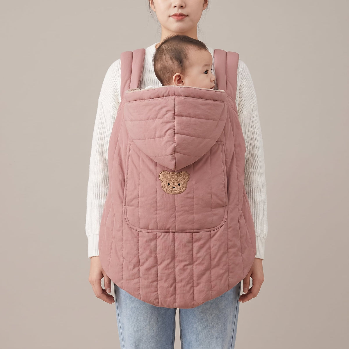 Mother wearing the blush quilted babywearing cover over her carrier — Orla Babywearing Cover — NAEVII#Color_Blush