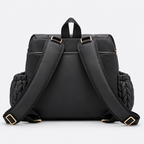 NAEVII Elara Diaper Bag Backpack in black, back view with padded shoulder straps, gold-tone buckles, top carry handle and quilted side pockets#Color_Black