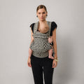 Woman carrying newborn in NAEVII Limitless Baby Carrier, black and white Houndstooth, front carry#Color_Houndstooth