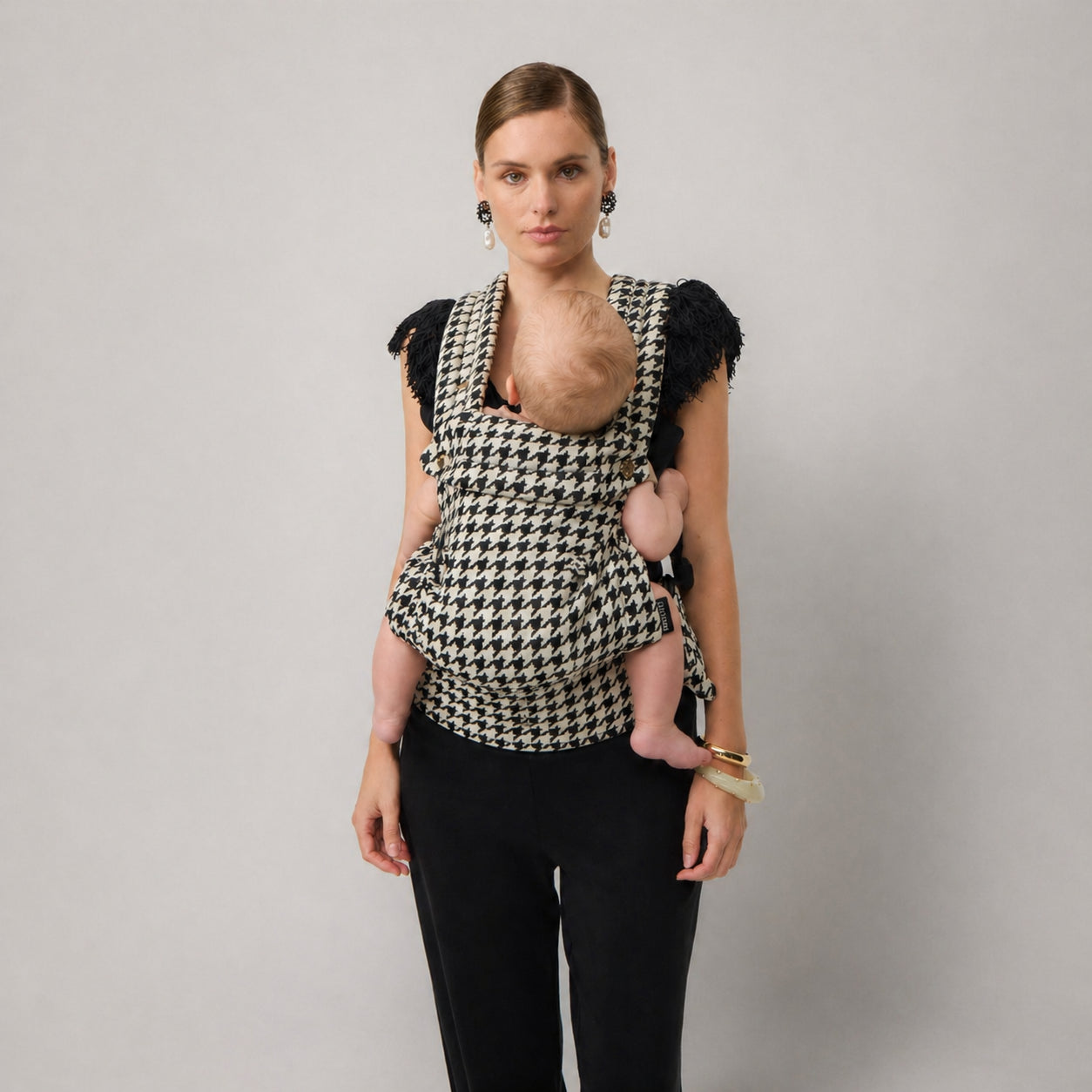 Woman carrying newborn in NAEVII Limitless Baby Carrier, black and white Houndstooth, front carry#Color_Houndstooth