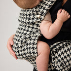 Baby seated in NAEVII Limitless Baby Carrier, black and white Houndstooth, close up of seat and zip pocket#Color_Houndstooth