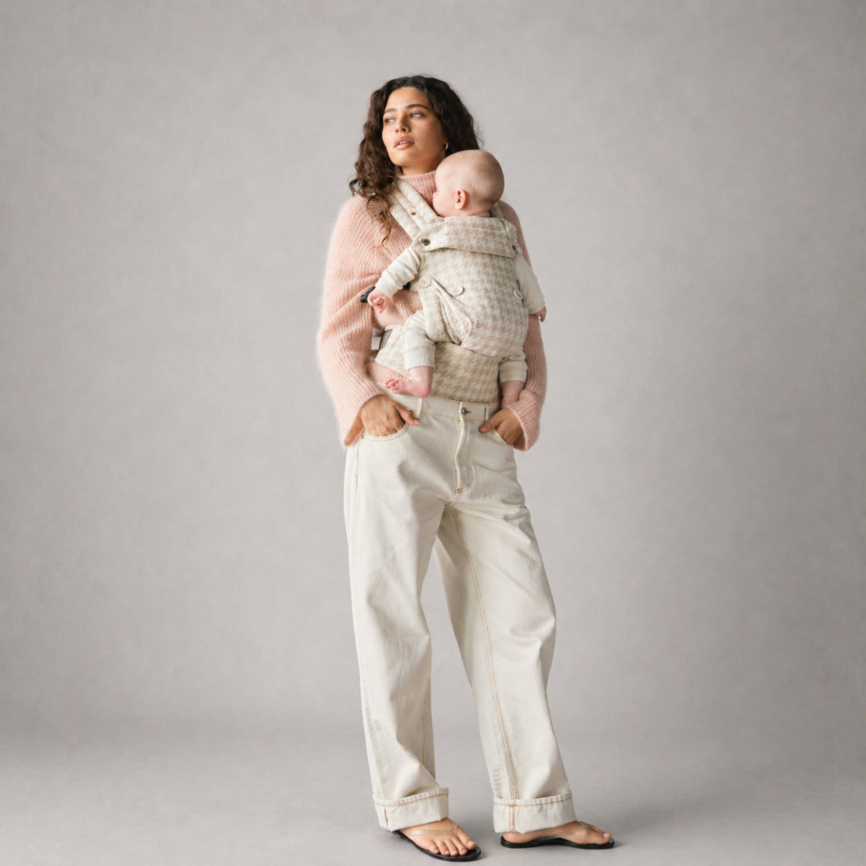 Woman carrying baby in NAEVII Limitless Baby Carrier, Neutral Houndstooth#Color_Neutral Houndstooth