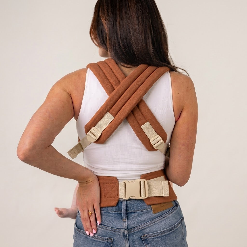 Crossable shoulder straps and waist buckle seen from behind, NAEVII Soft Baby Carrier in terracotta Brown#Color_Brown