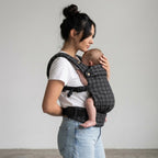 Woman carrying newborn in NAEVII Soft Baby Carrier, black Onyx Houndstooth, front carry#Color_Onyx Houndstooth
