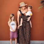 Woman carrying her toddler in the NAEVII Toddler Sling Carrier, brown leopard print, standing outdoors with her older daughter#Color_Brown Leopard
