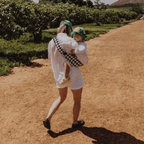 Woman walking a country path carrying her toddler in the NAEVII Toddler Sling Carrier, black and white Houndstooth, seen from behind#Color_Houndstooth